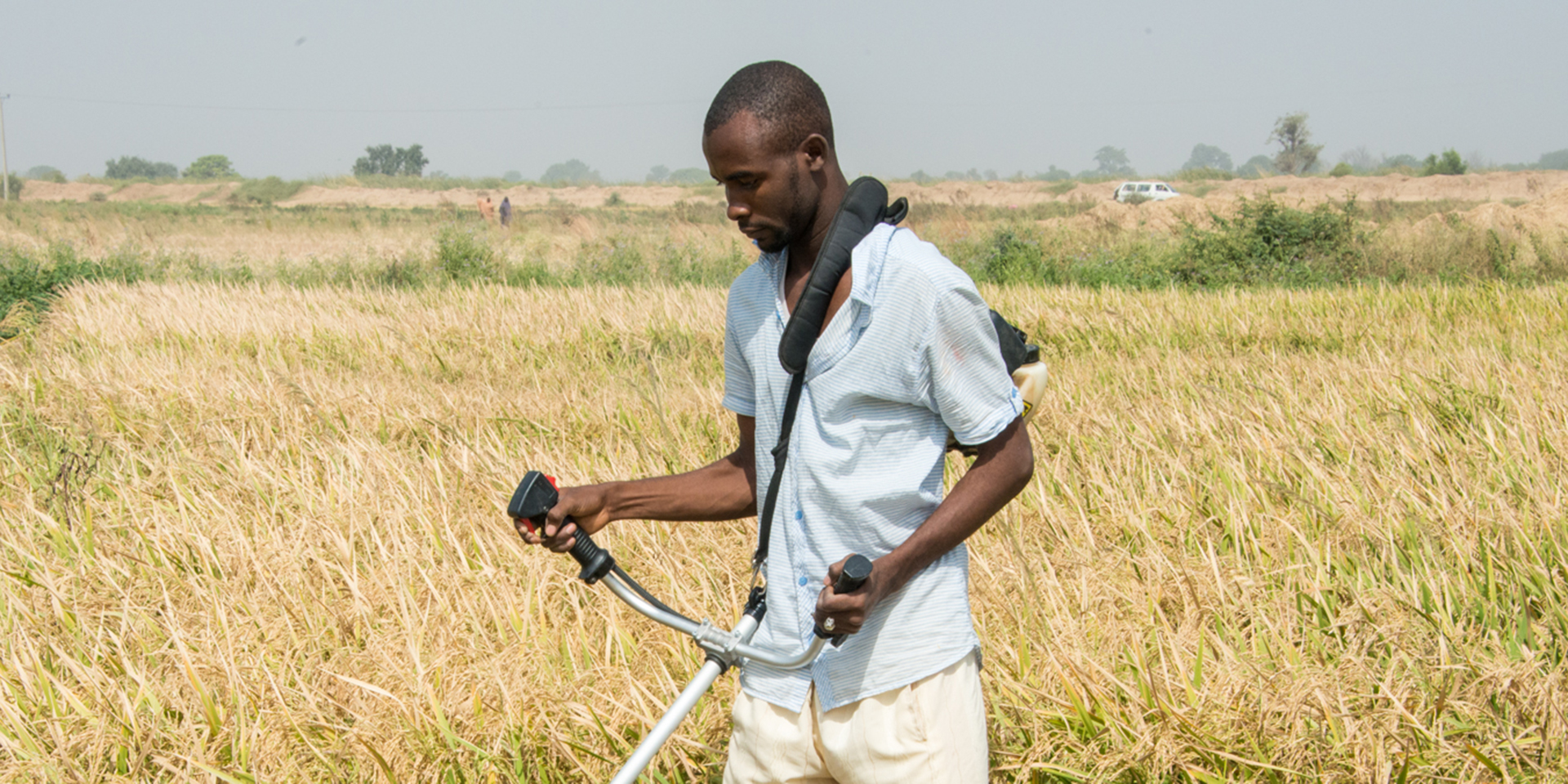 Aliyu Sambo Aliyu demonstrates how to harvest rice with a motorized reaper during a MARKETS II training event in Jigawa state on Nov. 24, 2016.