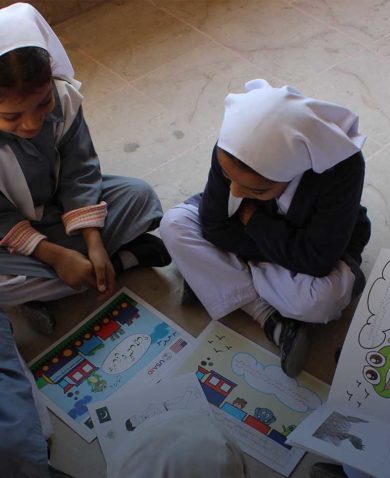 A group of four girls in Pakistan reading children's books in a school
