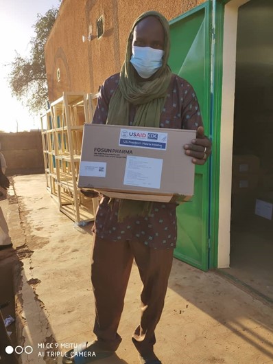 A man holding a box of health commodities that have been delivered to AB484_Bourgami.