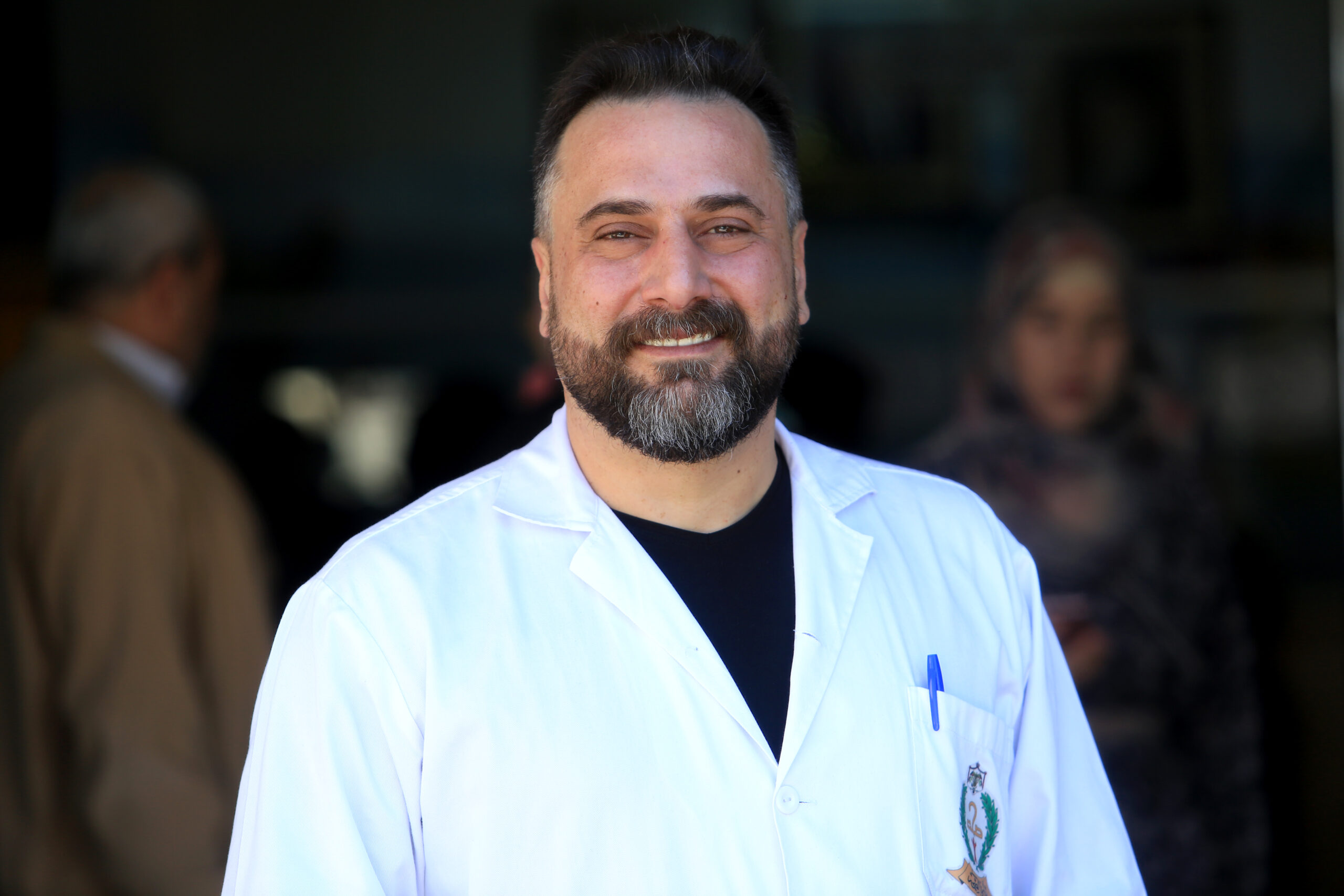 Photo of a smiling man in a white labcoat