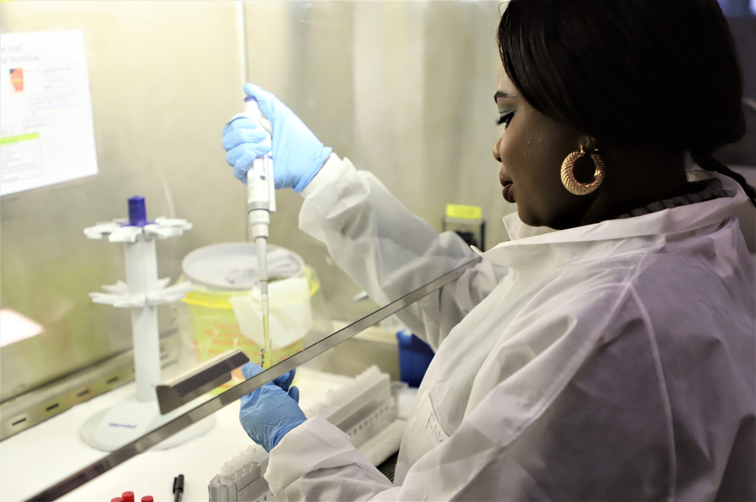 A woman prepares a lab sample for testing.