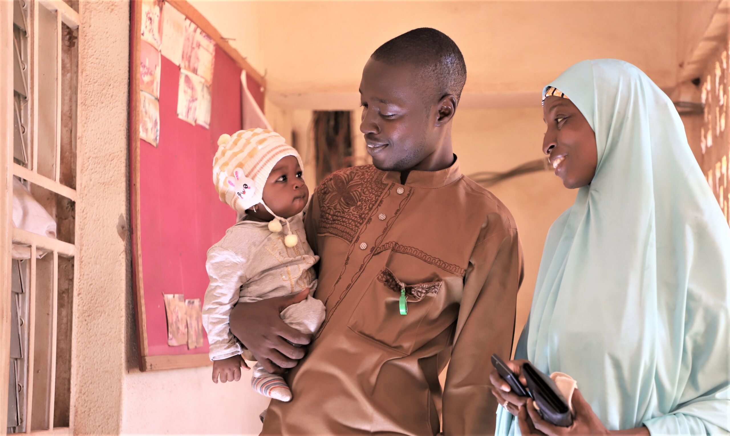 A couple holds a baby in their arms.