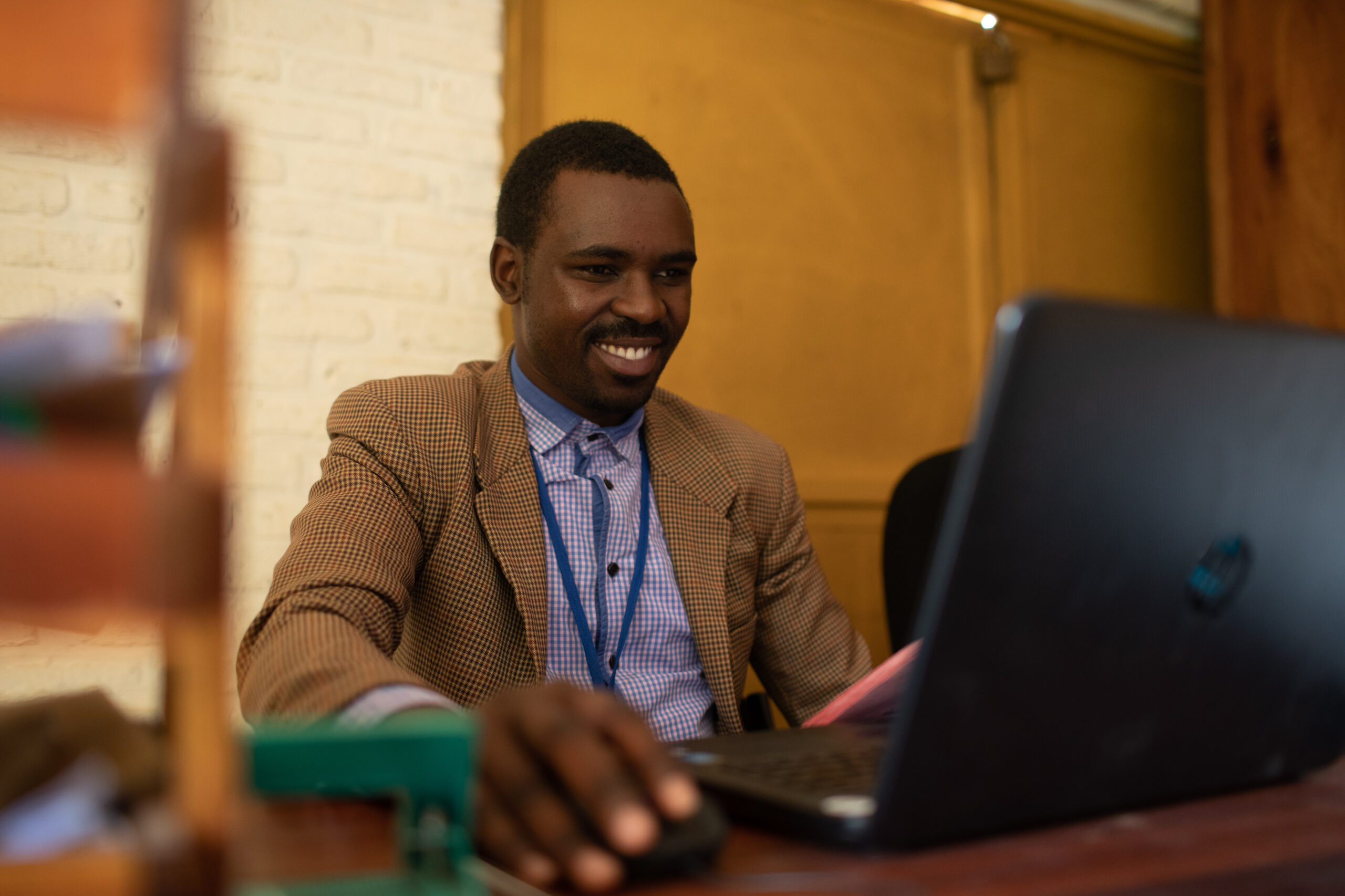 Man smiles while looking at his laptop