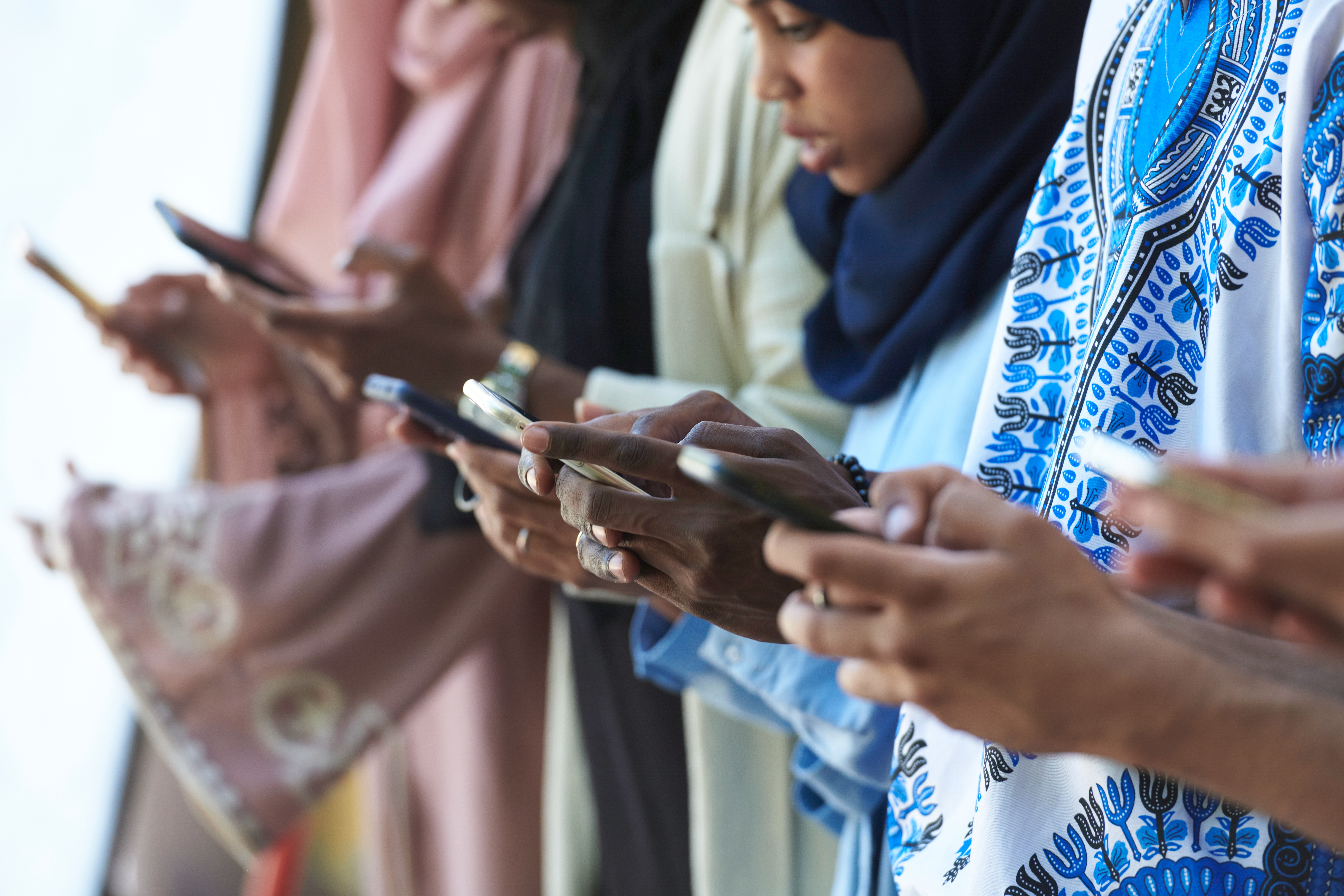 A group of people staring down at their smartphones