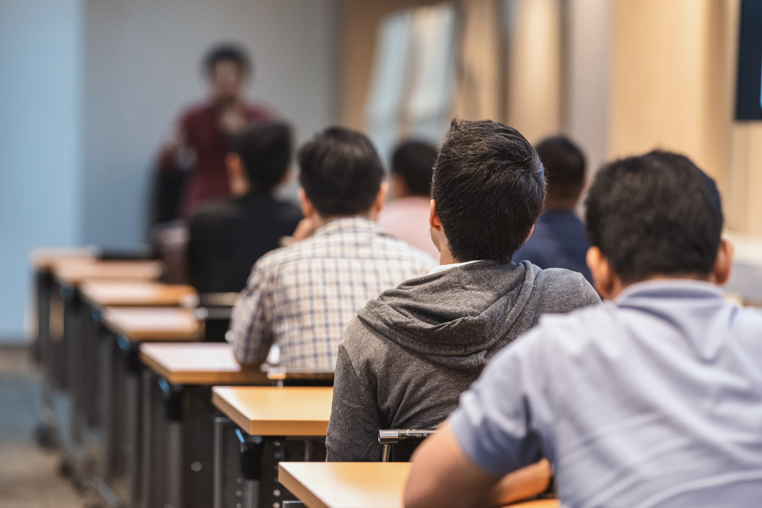Rear view of Audience listening to a speaker on the stage in the meeting room or conference hall